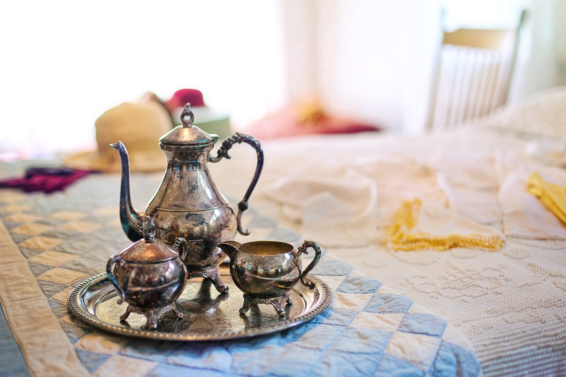 Silver teas set on a bed in a bed and breakfast